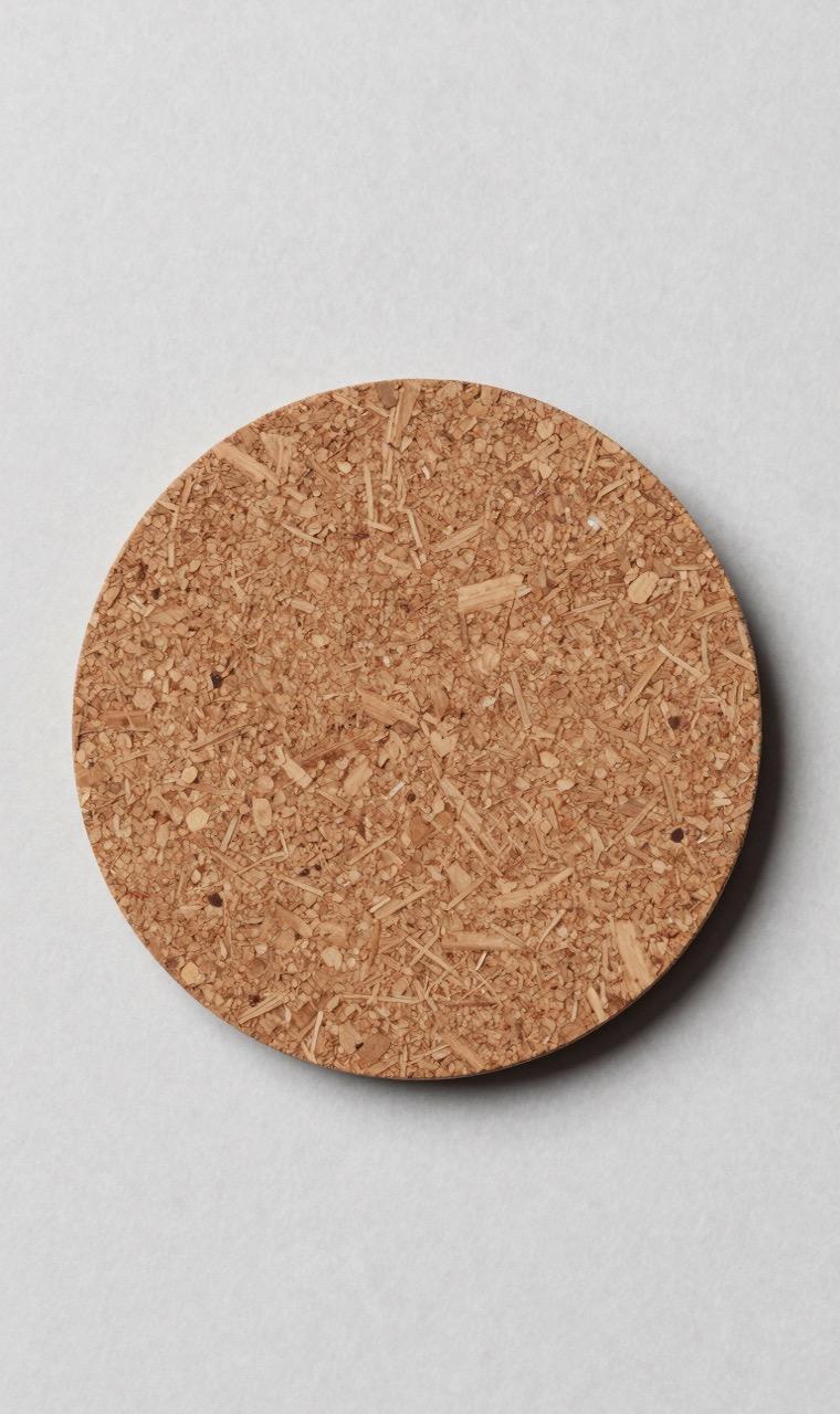 A cork backing being glued to a bead coaster